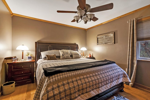 bedroom featuring ceiling fan, wood-type flooring, and ornamental molding