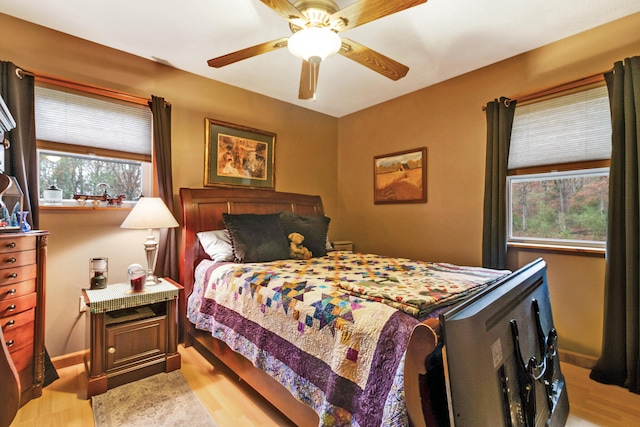 bedroom featuring multiple windows, light hardwood / wood-style floors, and ceiling fan