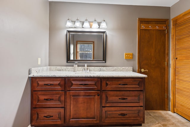 bathroom featuring tile patterned flooring, a closet, and vanity