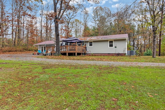 back of house with a gazebo, a wooden deck, and a lawn