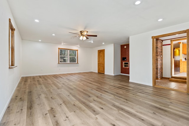 unfurnished living room featuring recessed lighting, ceiling fan, light wood-style flooring, and baseboards