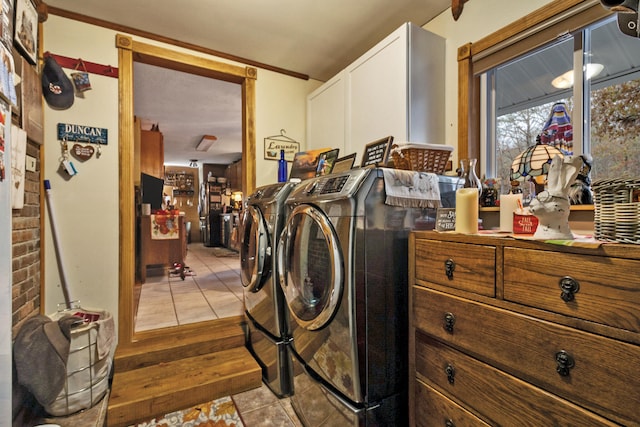 laundry room featuring cabinets, independent washer and dryer, and light tile patterned floors