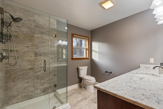 full bathroom featuring toilet, a stall shower, vanity, and baseboards