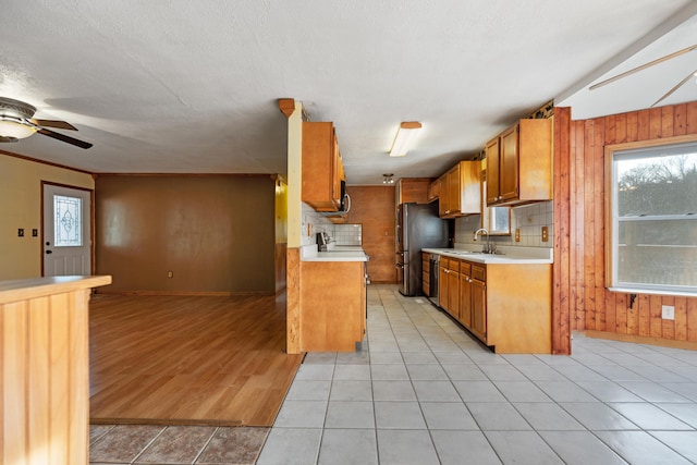 kitchen featuring light countertops, brown cabinets, a sink, and stainless steel appliances