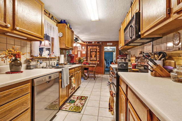 kitchen with dishwasher, stove, backsplash, light tile patterned floors, and a textured ceiling