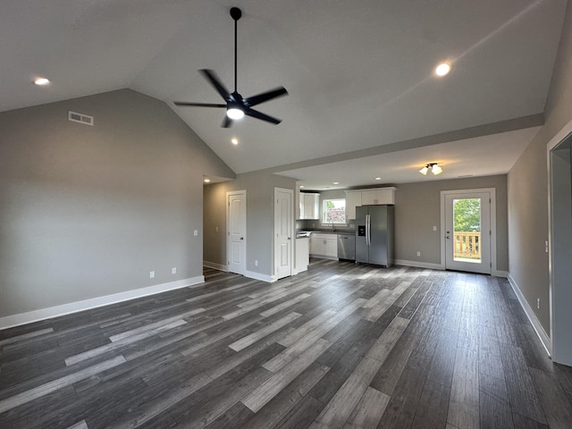 unfurnished living room with ceiling fan, dark hardwood / wood-style floors, and vaulted ceiling