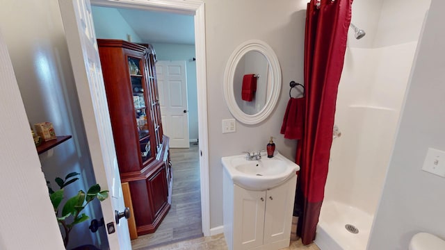 bathroom with sink, a shower with curtain, hardwood / wood-style floors, and toilet