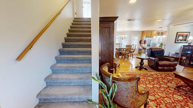 stairs featuring an inviting chandelier