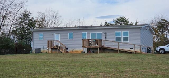 rear view of property featuring a lawn and central AC unit