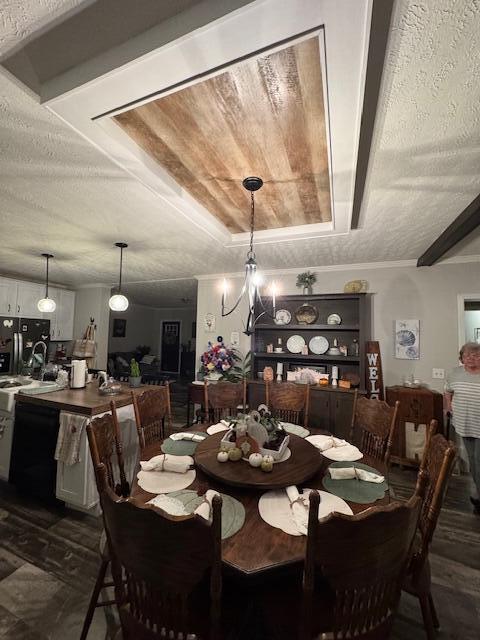 dining room with dark hardwood / wood-style floors, a textured ceiling, and an inviting chandelier