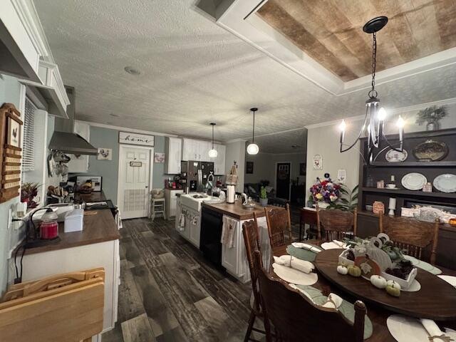 kitchen featuring a textured ceiling, white cabinetry, dark hardwood / wood-style floors, and wall chimney range hood