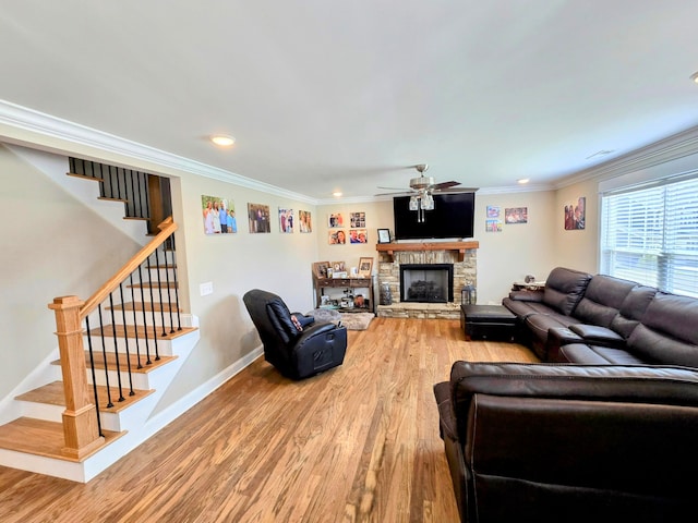 living room with ceiling fan, a fireplace, ornamental molding, and hardwood / wood-style flooring