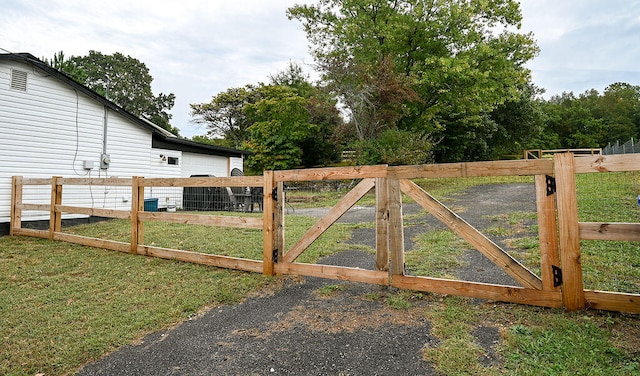 view of gate with a yard