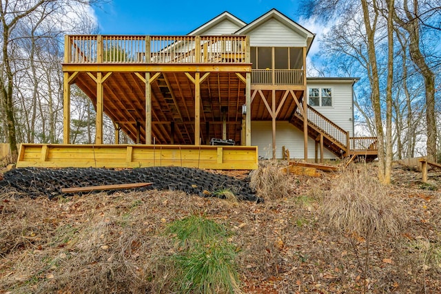 rear view of property with a wooden deck and a sunroom