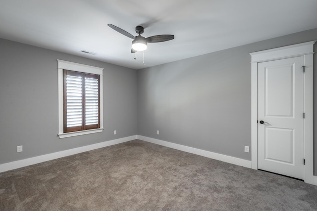 carpeted spare room featuring ceiling fan