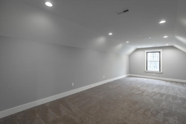 bonus room with lofted ceiling and carpet flooring