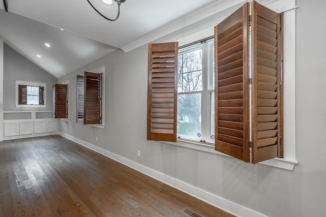 spare room featuring hardwood / wood-style flooring and vaulted ceiling