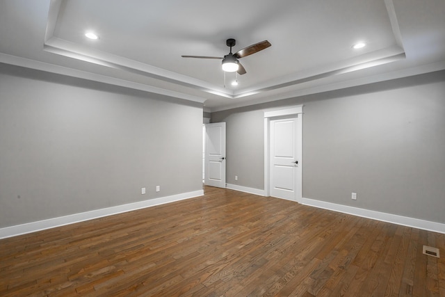 interior space featuring dark wood-type flooring, a raised ceiling, and ceiling fan