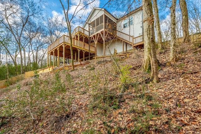 back of property featuring a wooden deck and a sunroom