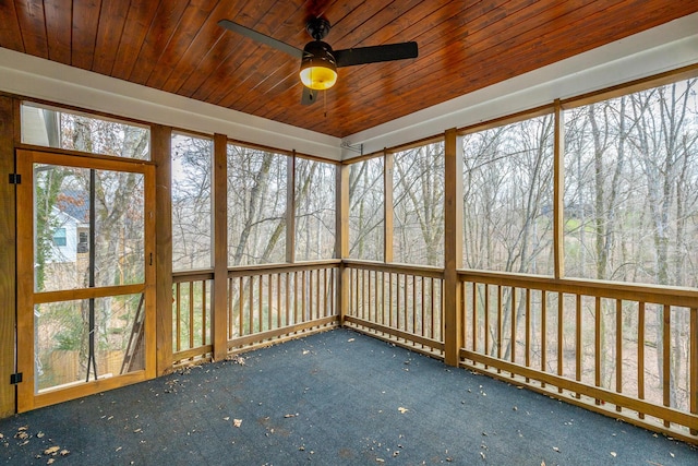 unfurnished sunroom featuring ceiling fan, a healthy amount of sunlight, and wooden ceiling