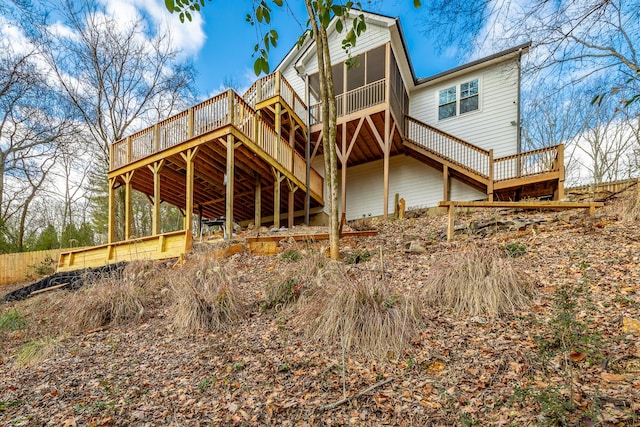 rear view of property with a wooden deck and a sunroom