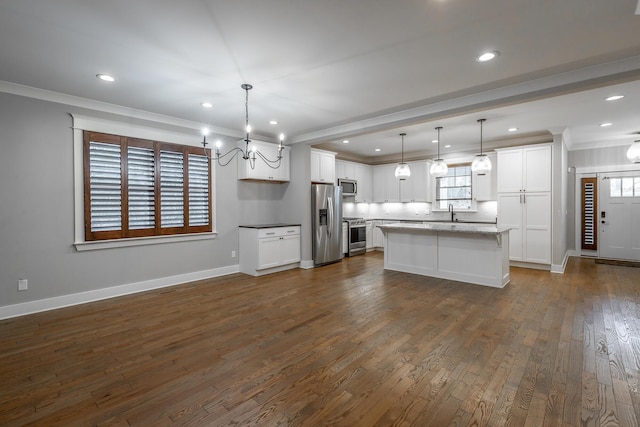 kitchen featuring white cabinetry, hanging light fixtures, a center island, and appliances with stainless steel finishes