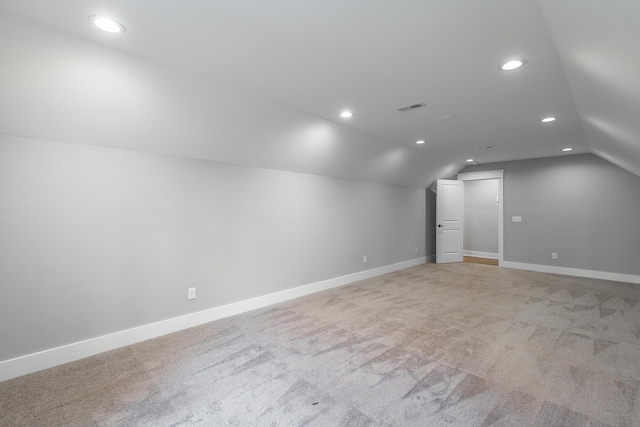 bonus room featuring vaulted ceiling and light colored carpet