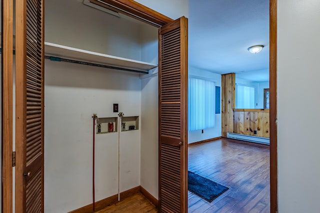 clothes washing area with baseboard heating and hardwood / wood-style flooring