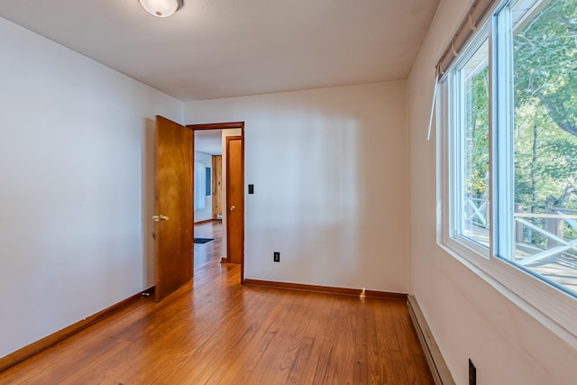 spare room with light hardwood / wood-style floors and a baseboard heating unit