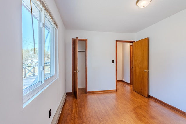 unfurnished bedroom with a closet and light hardwood / wood-style floors