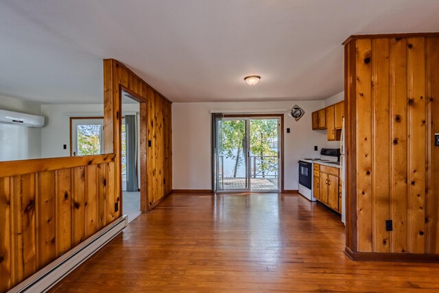 1336 Whites Creek Rd, Spring City, TN 37381 - kitchen with white electric stove, a baseboard radiator, wood-type flooring, a wall mounted air conditioner, and baseboards