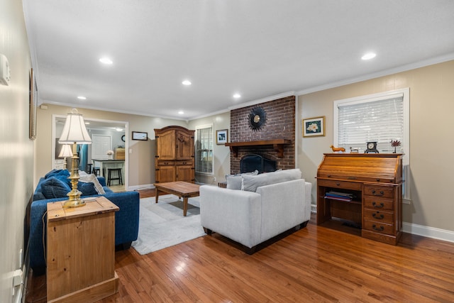 living room featuring hardwood / wood-style floors, ornamental molding, and a brick fireplace