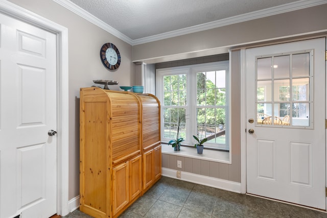 doorway to outside with a textured ceiling, dark tile patterned floors, and ornamental molding