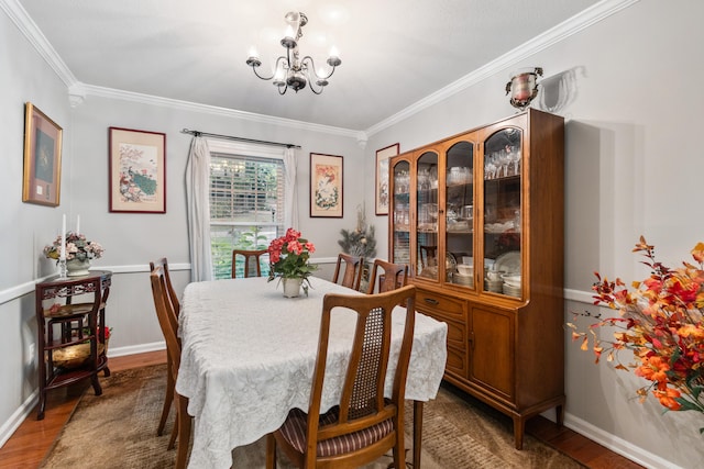 dining area with a chandelier, dark hardwood / wood-style flooring, and ornamental molding