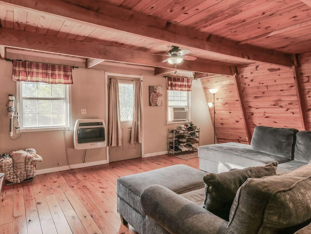 living area featuring ceiling fan, light hardwood / wood-style floors, beam ceiling, and heating unit