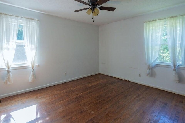 unfurnished room with ceiling fan and dark wood-type flooring