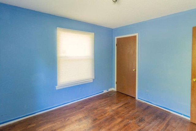 spare room with dark wood-type flooring