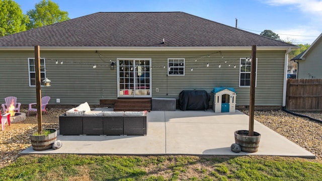 rear view of house featuring a shingled roof, a patio area, an outdoor living space with a fire pit, entry steps, and fence