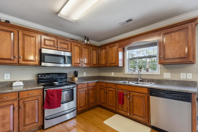 kitchen with brown cabinets, stainless steel appliances, and visible vents
