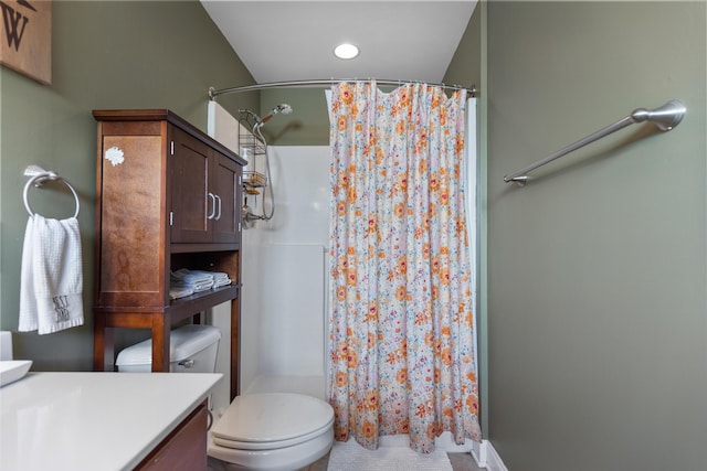 bathroom with a stall shower, toilet, and vanity