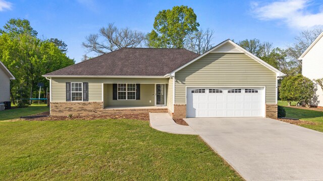ranch-style house with driveway, covered porch, a front yard, an attached garage, and brick siding