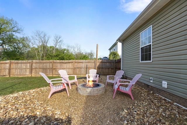 view of yard with fence and an outdoor fire pit
