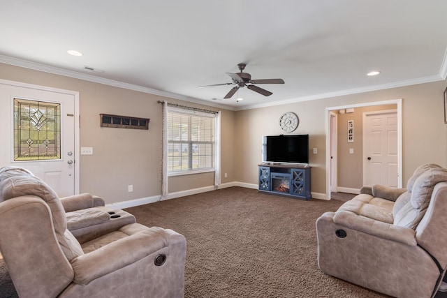 living area with baseboards, ornamental molding, and a ceiling fan