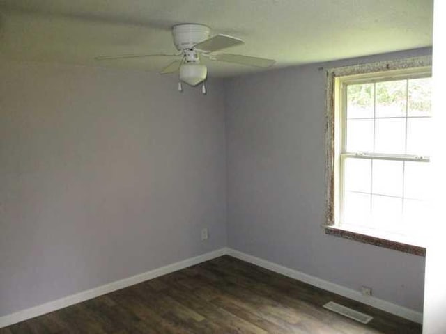 empty room with dark hardwood / wood-style flooring and ceiling fan