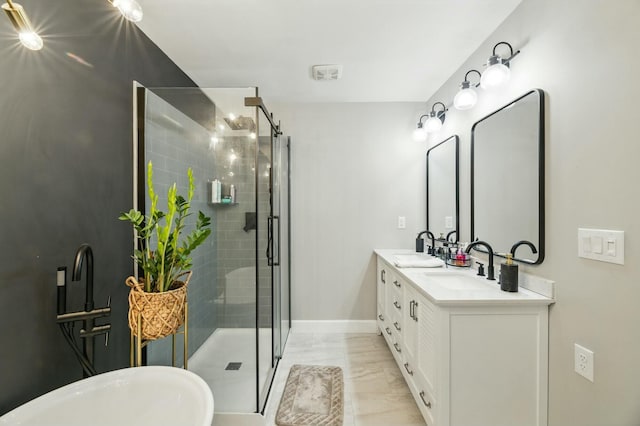 full bath featuring a stall shower, double vanity, a sink, and baseboards