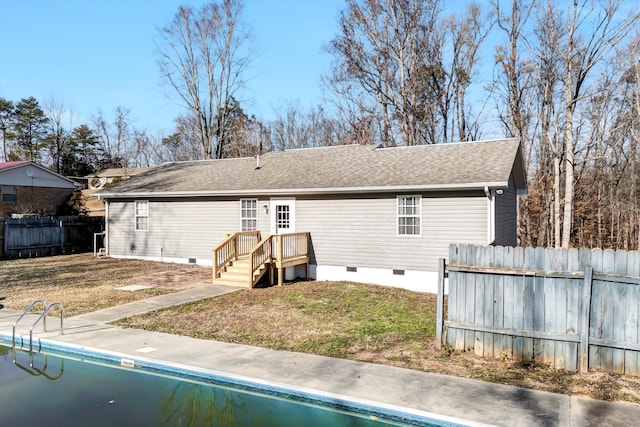 rear view of house featuring a fenced in pool and a lawn