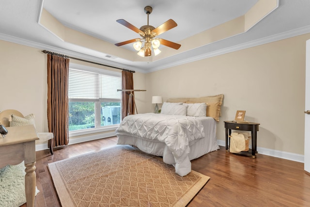 bedroom featuring a tray ceiling, ceiling fan, and hardwood / wood-style flooring