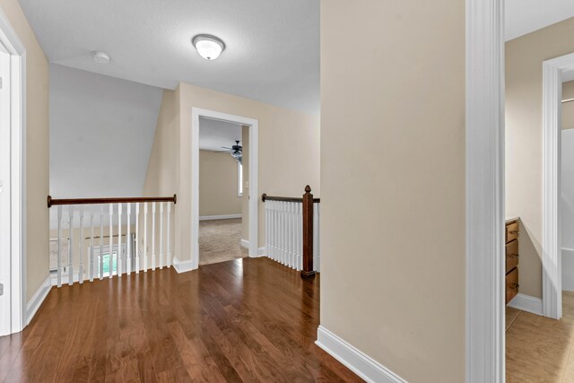 hallway featuring wood-type flooring and a textured ceiling