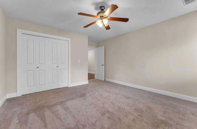 unfurnished bedroom with light carpet, a closet, and ceiling fan