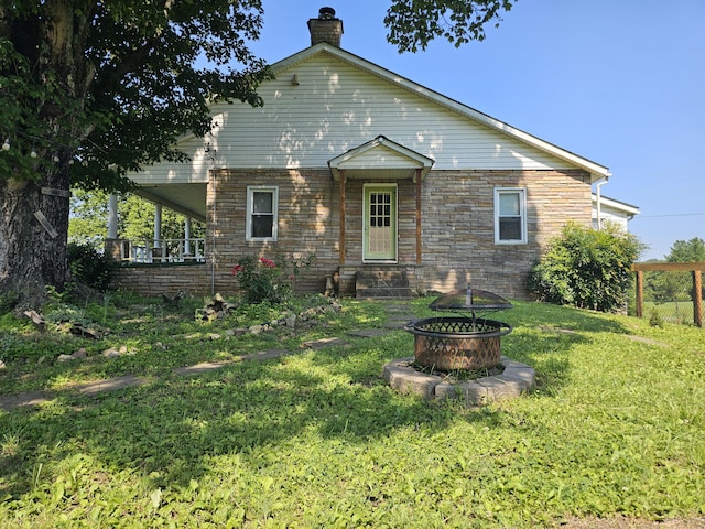 2783 No Pone Rd NW, Georgetown, TN 37336 - back of property with a chimney, an outdoor fire pit, a yard, and stone siding